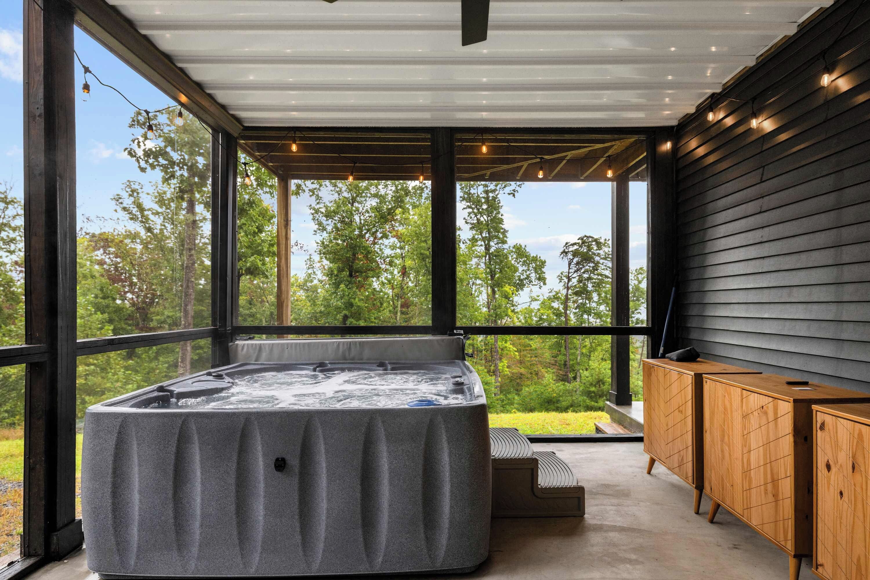 A hot tub in a modern outdoor setting with a view of trees.