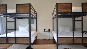 Une chambre avec deux lits superposés, une petite table avec une lampe et une prise de courant.
