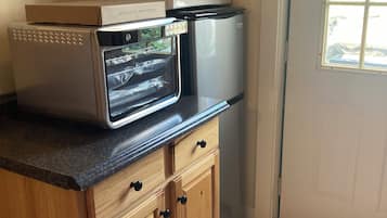 Eine Küche mit Mikrowelle, Backofen und Schränken mit Schubladen.