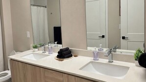 Et moderne badeværelse med et dobbelt vaskeskab, toilet og bruseområde.