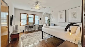Une chambre d’hôtel moderne équipée d’un lit, d’un bureau et d’un coin salon.