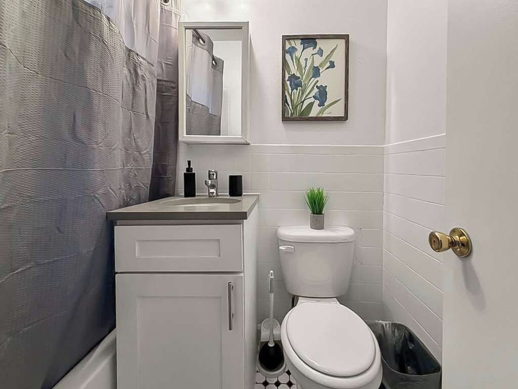 A bathroom with a toilet, sink, and a small potted plant.