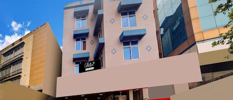 A multi-story building with a ground-level commercial space, including a restaurant with visible food items and a staircase leading to an upper floor.