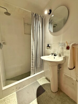 A bathroom with a shower, a sink, a mirror, and a towel rack. - Spacious 3-bedroom apartment near Zona T, a charming neighborhood (Bogotá)