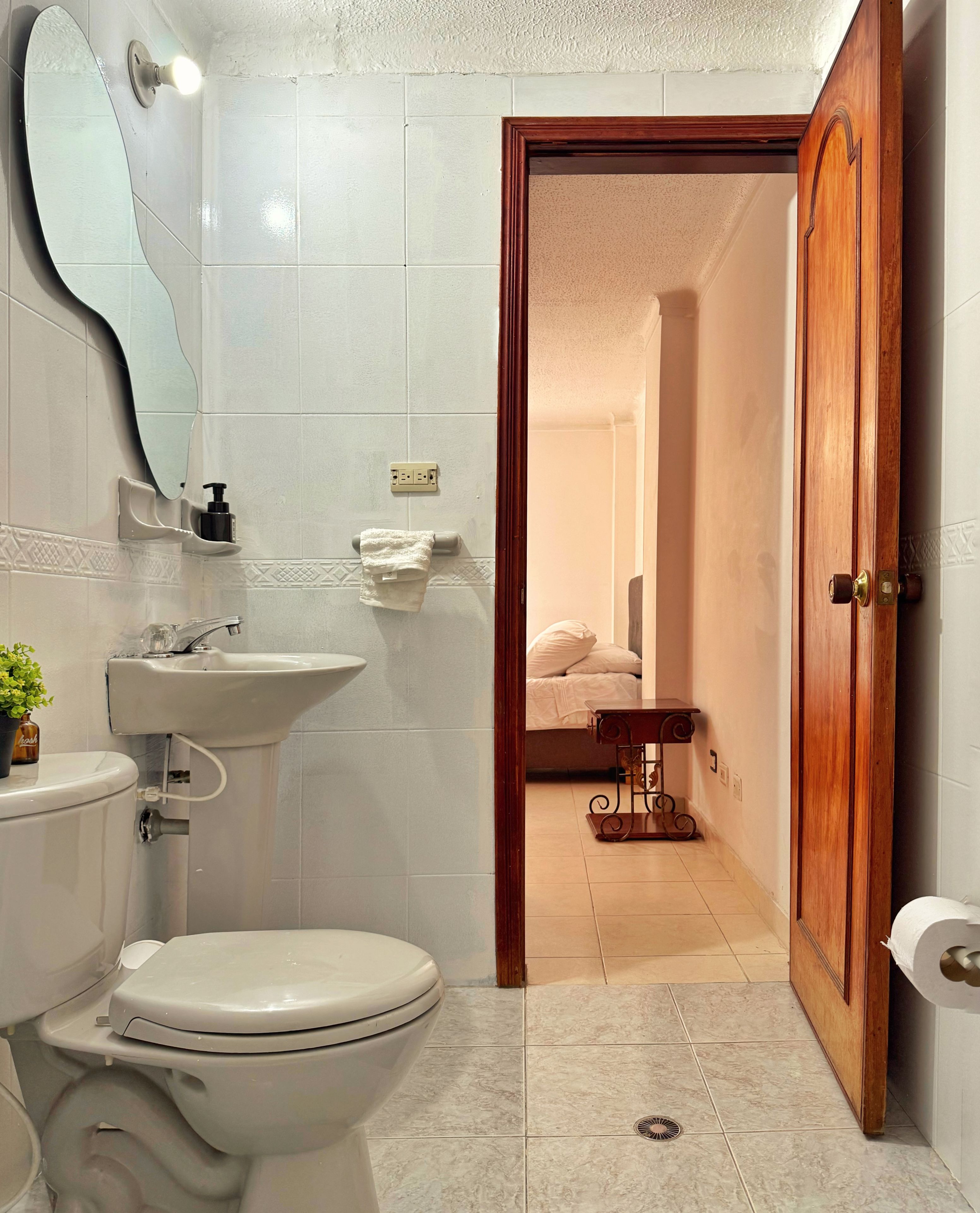 Une salle de bain avec des toilettes, un lavabo et un miroir.