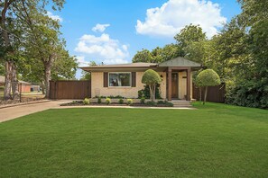 A single-story house with a front porch, a well-maintained lawn, and a wooden fence. - Close to UNT & TWU.  Easy stays for college families! (Denton)