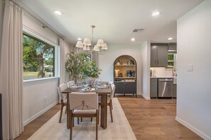 A dining area with a table set for four, a chandelier, and a view of the outdoors through a window. - Close to UNT & TWU.  Easy stays for college families! (Denton)