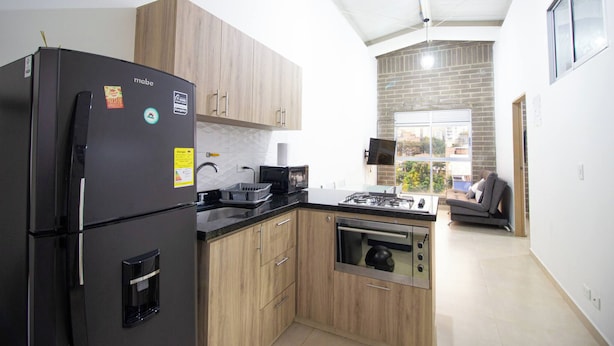 A modern kitchen with a built-in oven, a refrigerator, and a gas stove. - 51 Close to Laureles, Metro and Restaurants (Medellín)