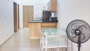 A compact kitchen with a gas stove, microwave, and wooden cabinets. - 51 Close to Laureles, Metro and Restaurants (Medellín)