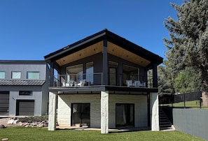 A modern two-story house with a balcony, large windows, and a stone facade. - Sopris Mountain Retreat w/ Pool & Mountain Views (Carbondale)