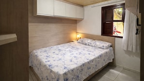 Un dormitorio pequeño con una cama individual, una mesita de noche, un ventanal con vista a una bicicleta y un techo de madera.