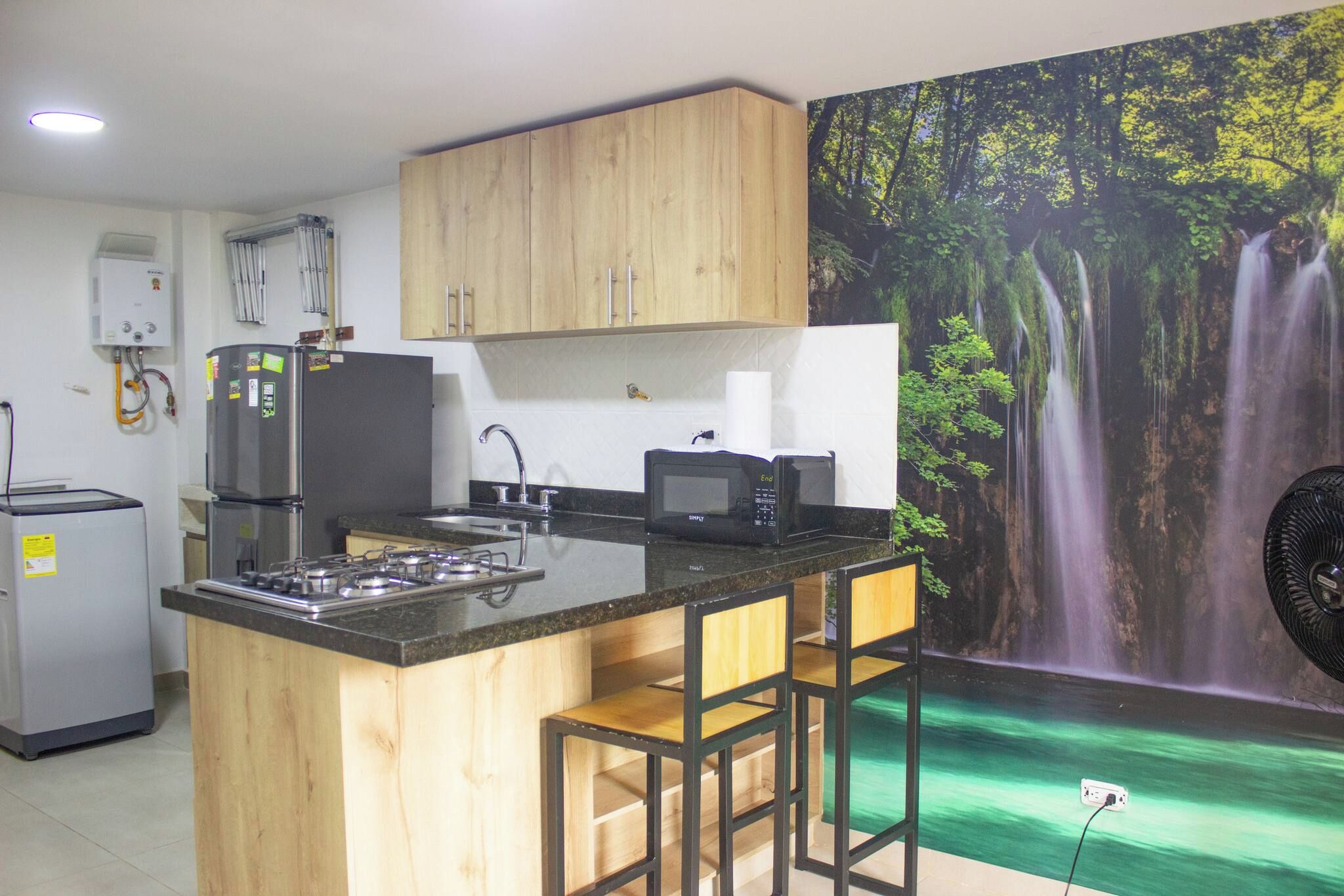 A kitchen with wooden cabinets, a gas stove, a refrigerator, a microwave, and a sink.