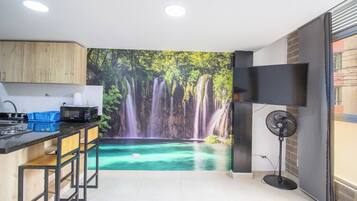 Una cocina con un mural de cascada, microondas y ventilador.