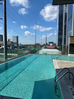 A swimming pool with clear water, surrounded by a modern building with large windows. - The Royal Suite luxury apartment Downtown Atlanta Views (Atlanta)