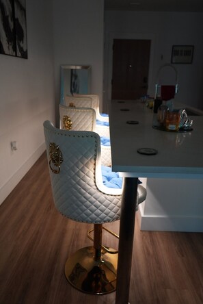 Ein Essbereich mit Tisch, Stühlen und einer Küche im Hintergrund.
