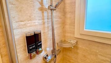 Ducha con cabezal de ducha de mano y grifo empotrado.