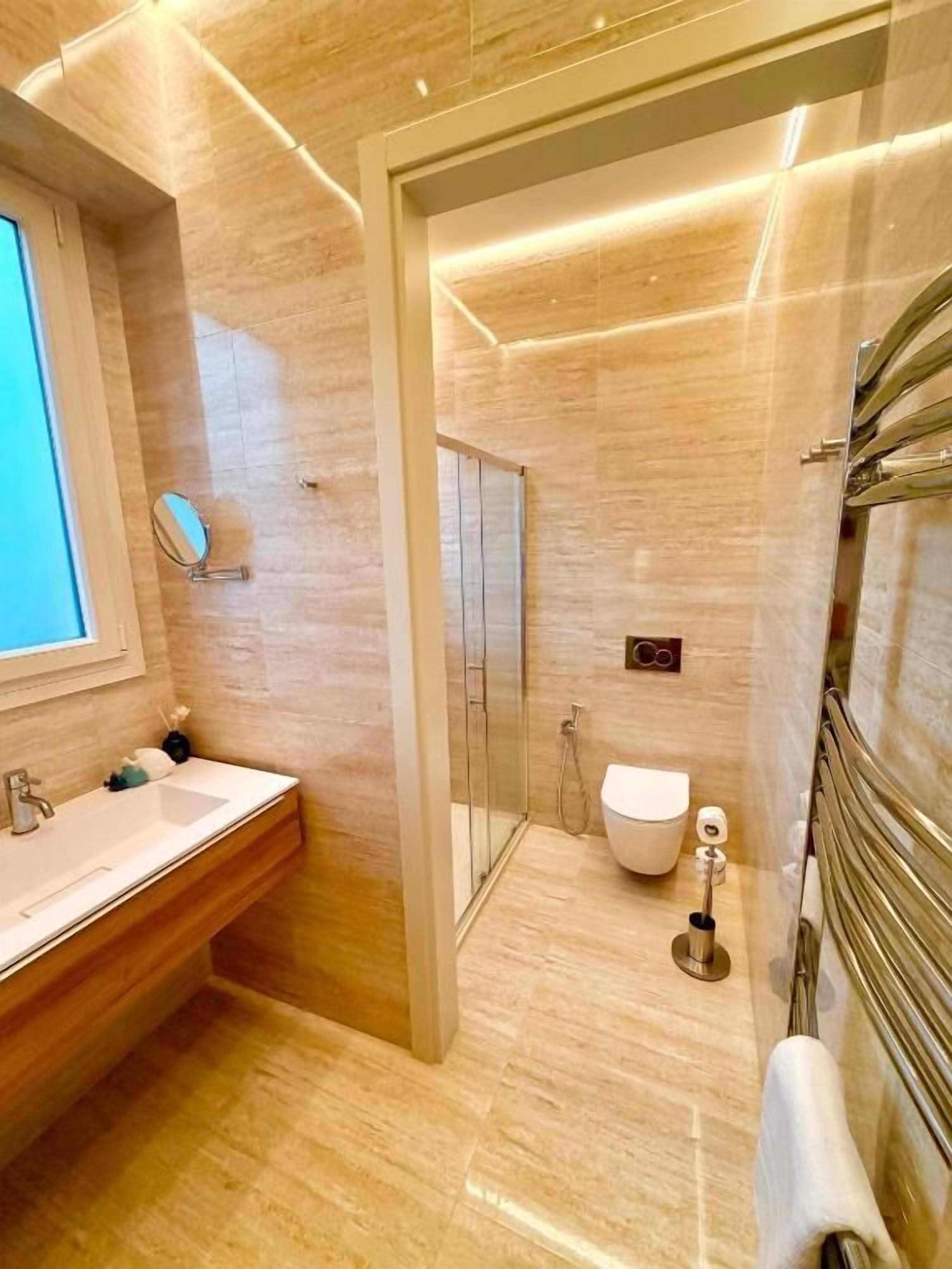 Ein modernes Badezimmer mit Duschkabine aus Glas, Toilette und Waschbecken mit Spiegel.
