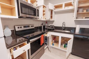 A modern kitchen with white cabinetry, a stainless steel stove, a microwave, and a dishwasher. - Mins 2 Everbank - Baptist UF - Health - Beach - Airport (Jacksonville)
