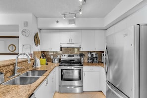 A modern kitchen with stainless steel appliances, granite countertops, and white cabinetry. - Aventura Palm Retreat - 2BR Pool Gym Tennis (Aventura)