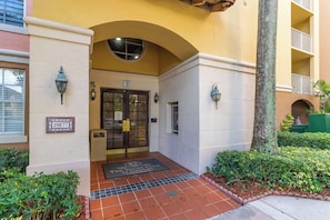 A building entrance with a glass door, a number sign, and a small trash bin. - Aventura Palm Retreat - 2BR Pool Gym Tennis (Aventura)