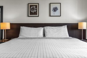 A hotel room with a large bed, two pillows, a headboard, two bedside lamps, and two framed floral artworks on the wall. - Aventura Palm Retreat - 2BR Pool Gym Tennis (Aventura)