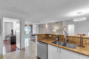 A modern kitchen with granite countertops, stainless steel appliances, and a built-in dishwasher. - Aventura Palm Retreat - 2BR Pool Gym Tennis (Aventura)