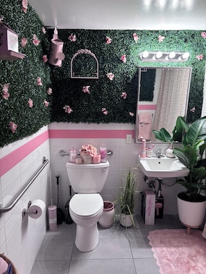 Une salle de bain avec des toilettes, un lavabo et un miroir.