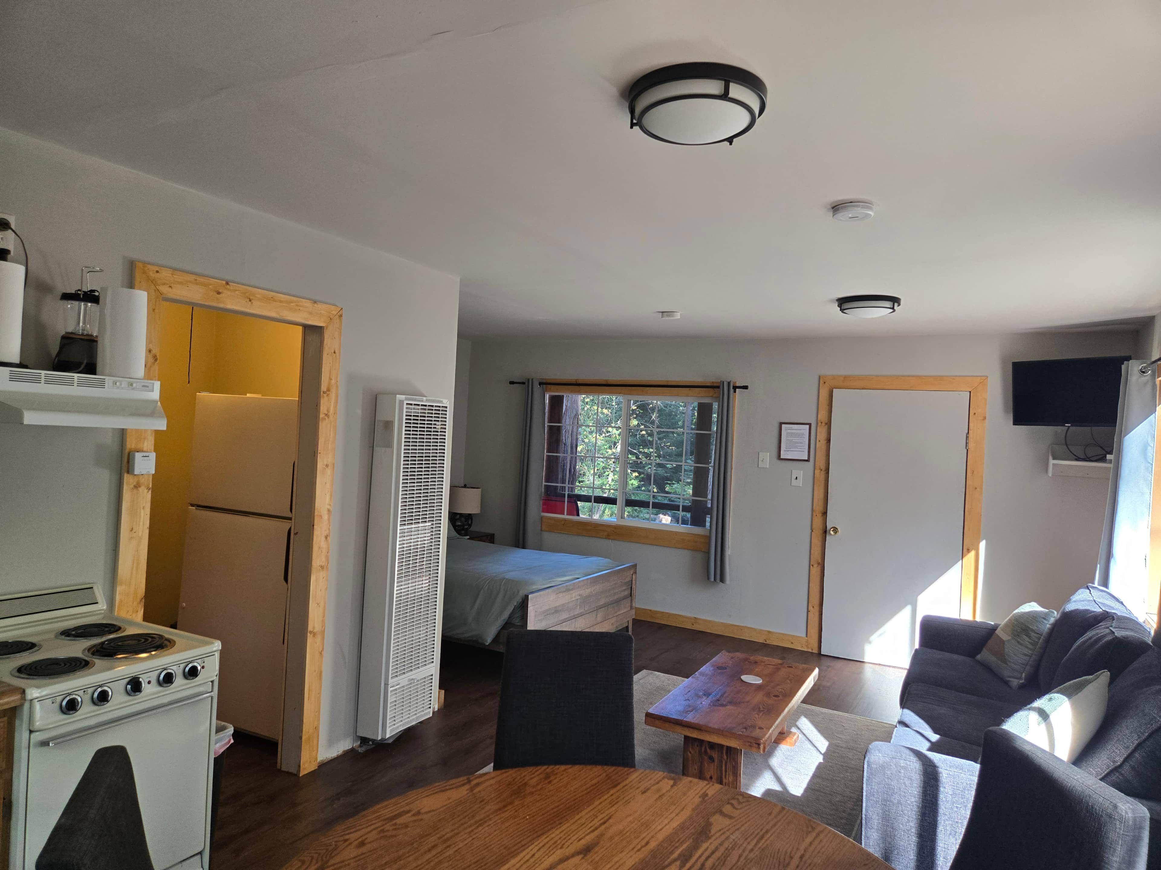 A compact living space with a kitchenette, a dining area, and a seating area with a couch.