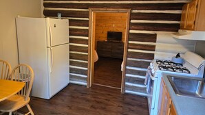 Eine Küche mit Kühlschrank, Herd und Holzschränken.