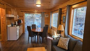Ein Interieur einer Holzhütte mit Küche, Essbereich und Sitzgelegenheiten.