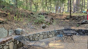 Eine Außenpatio mit Steinmauern, Metallstühlen und einem Tisch.