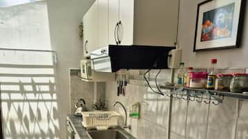 A compact kitchen with a gas stove, a sink, and a microwave.