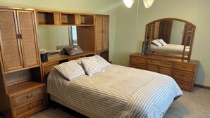 A bedroom with a bed, a dresser, a nightstand, a mirror, and a ceiling fan. - Perfect 3-bedroom farmhouse with AC in pleasant Washington (Washington)