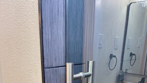 Un baño con cabina de ducha de vidrio, pomo de acero inoxidable y lavamanos con grifo negro.