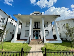 Um edifício de dois andares com entrada central, grandes janelas e fachada simétrica.