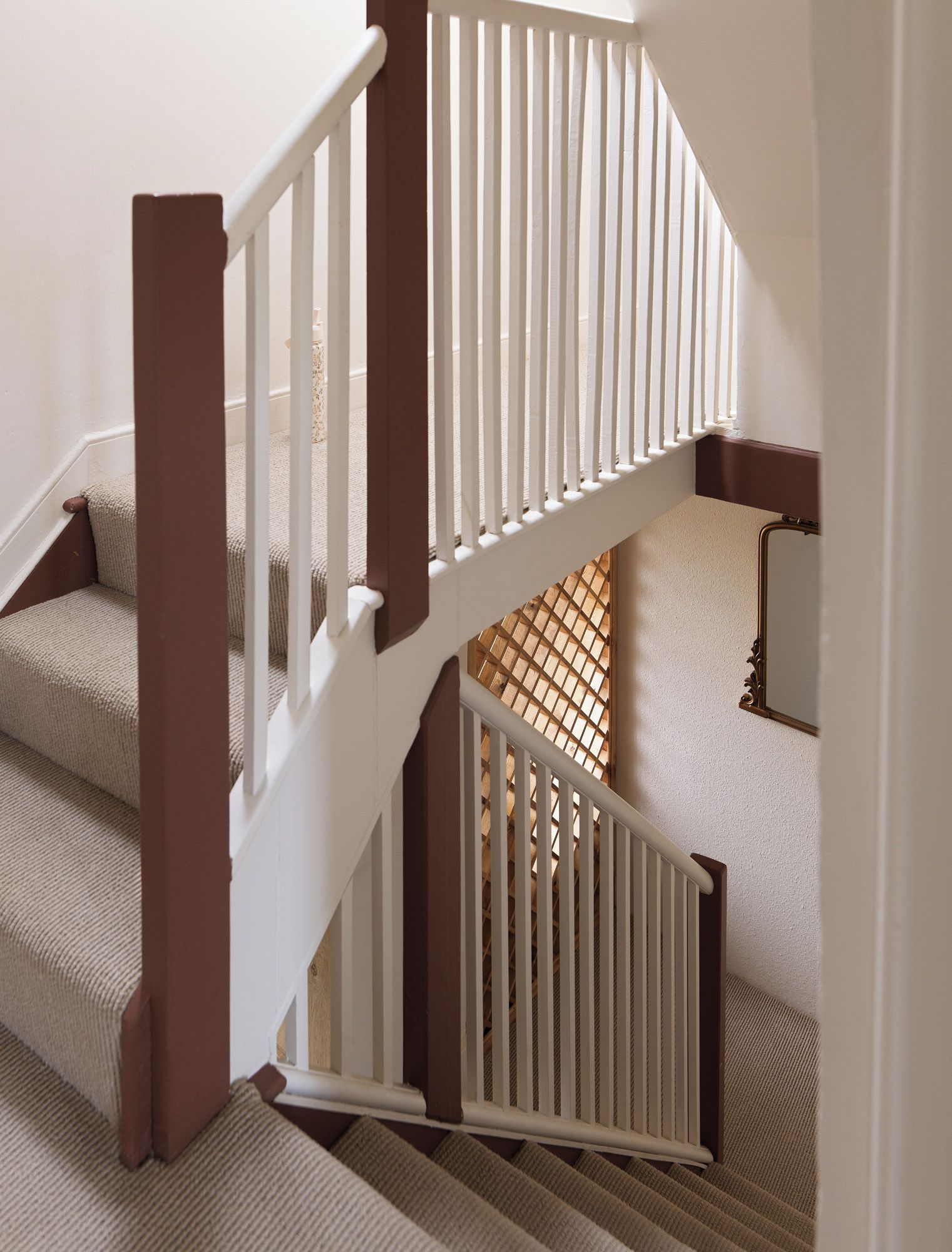 A staircase with white railings and brown steps.