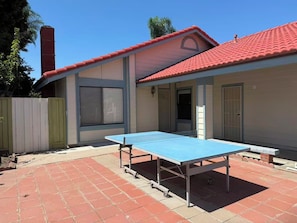 A residential building with a red-tiled roof, a blue ping pong table in the backyard, and a green fence. - 3b2b single story house in beautiful Chino with New kitchen/Ping-Pong table/WIFI (Chino)