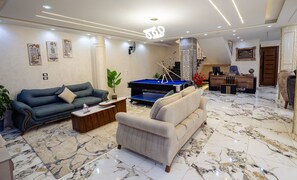 A spacious living area with a pool table, two sofas, a coffee table, and a reception desk. - The "Villa of Dreams VIP" is reserved exclusively for families. The renter is required to provide a security deposit, which will be refunded upon checkout. (Giza Governorate)