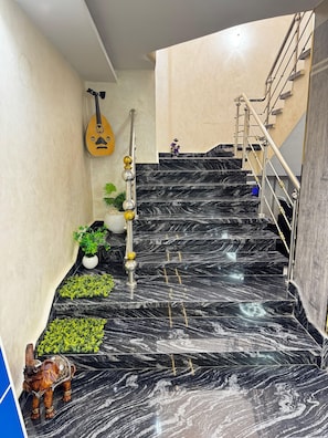 A staircase with black marble steps, a handrail, and a wall-mounted decorative item. - The "Villa of Dreams VIP" is reserved exclusively for families. The renter is required to provide a security deposit, which will be refunded upon checkout. (Giza Governorate)