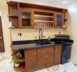 A kitchen with wooden cabinets, a black countertop, a sink, and a dishwasher. - The "Villa of Dreams VIP" is reserved exclusively for families. The renter is required to provide a security deposit, which will be refunded upon checkout. (Giza Governorate)