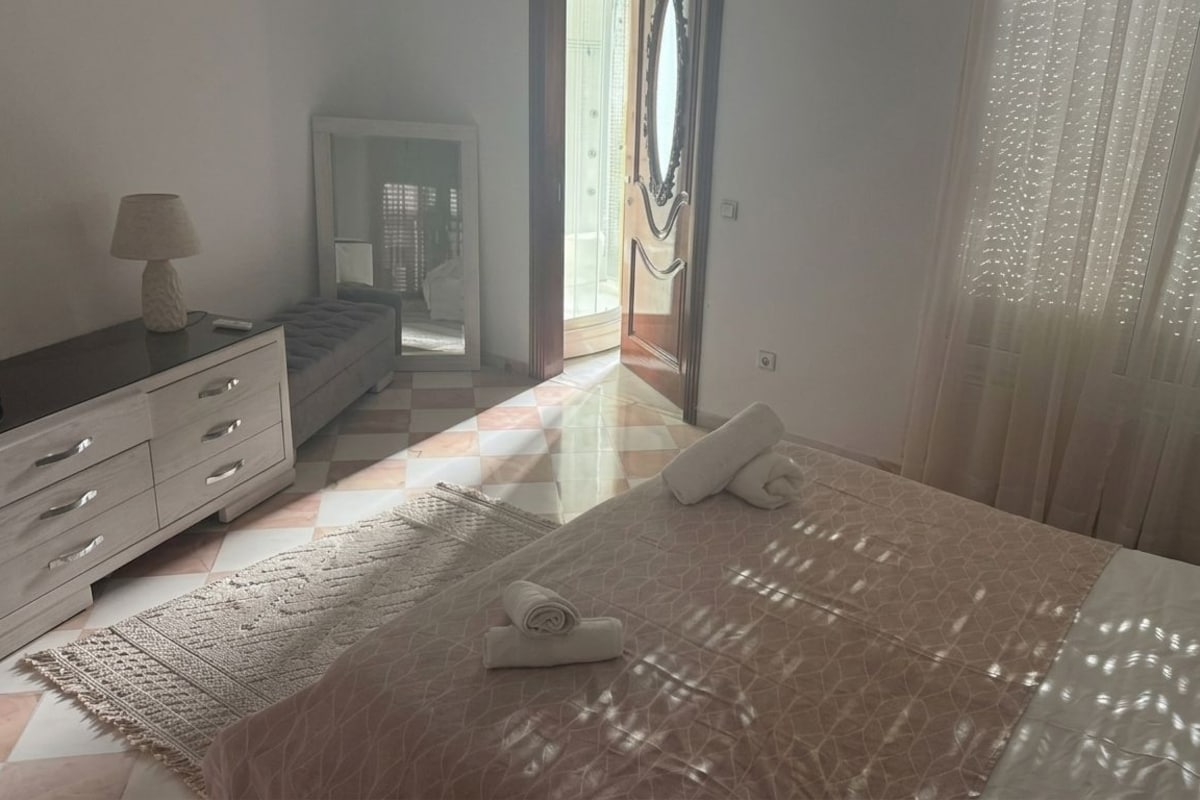 Une chambre d’hôtel avec un lit, une table de chevet, une lampe, une fenêtre avec des rideaux et une vue sur l’extérieur.