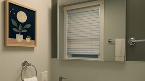 A bathroom with a white sink, a mirror, a window with blinds, a towel ring, and a framed artwork on the wall. - Delightful 1BR Apt in Ravenswood (Chicago)