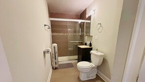 Un baño con inodoro, lavamanos y ducha.
