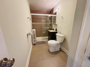 A bathroom with a toilet, sink, and shower. - Homey Vibes 1BR Apt near Lake Michigan & UChicago (Chicago)