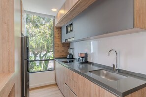 Eine moderne Küche mit einem großen Fenster, Edelstahlgeräten und einer Spüle mit zwei Becken.