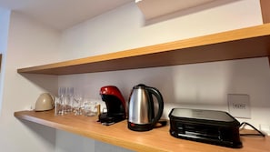 A kitchen shelf with a coffee maker, a kettle, and several glasses. - Ocean view in Salvador (Salvador)