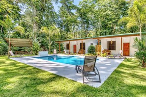 A house with a swimming pool, surrounded by lush greenery and a covered patio area. - Haze Villa | Tropical Retreat & Pool (Puerto Viejo De Talamanca)