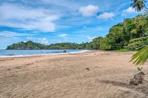 A beach with clear skies, calm water, and lush greenery. - Kush Villa | Caribbean Hideaway & Pool (Puerto Viejo de Talamanca)
