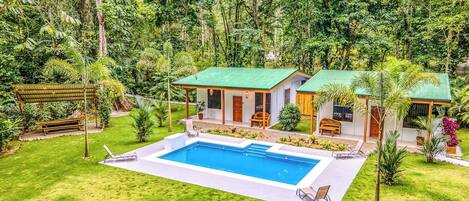 Uma casa com piscina, rodeada por vegetação exuberante.
