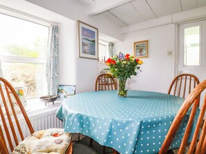 Ein Essbereich mit einem Tisch, der mit einer Tischdecke mit Punkten bedeckt ist, umgeben von Holzkästen.